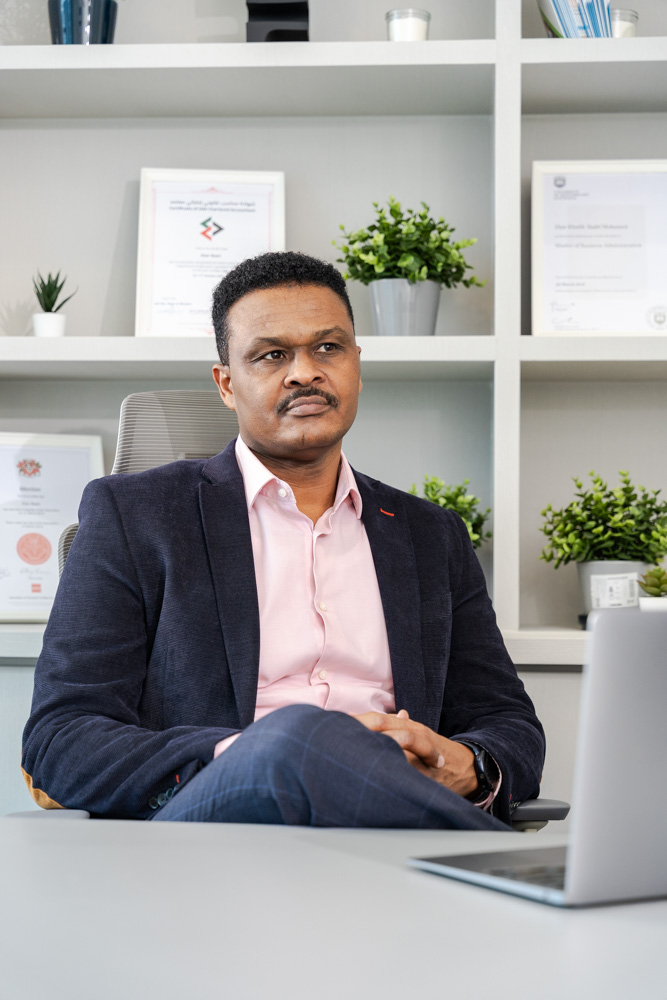 Elsir Badri reviewing work at his desk